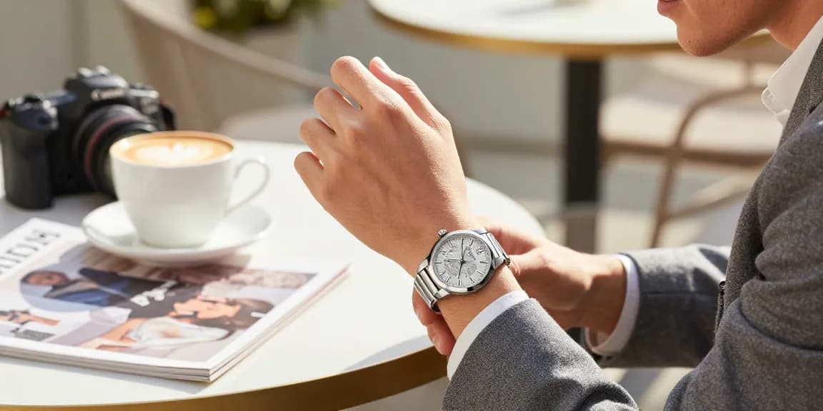 Clone watches displayed elegantly on a wrist, embodying luxury and style in a chic café setting.